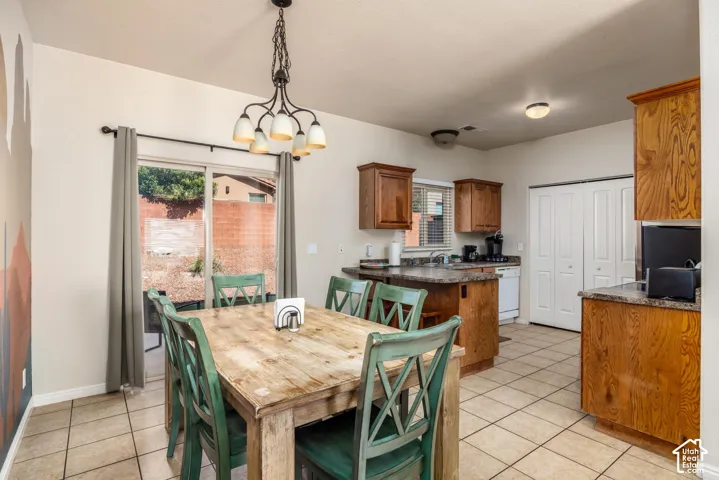Open-concept kitchen and dining area featuring tile flooring, wooden cabinetry, and countertops