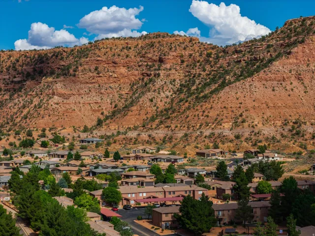 Residential community situated against a prominent red rock mountain backdrop