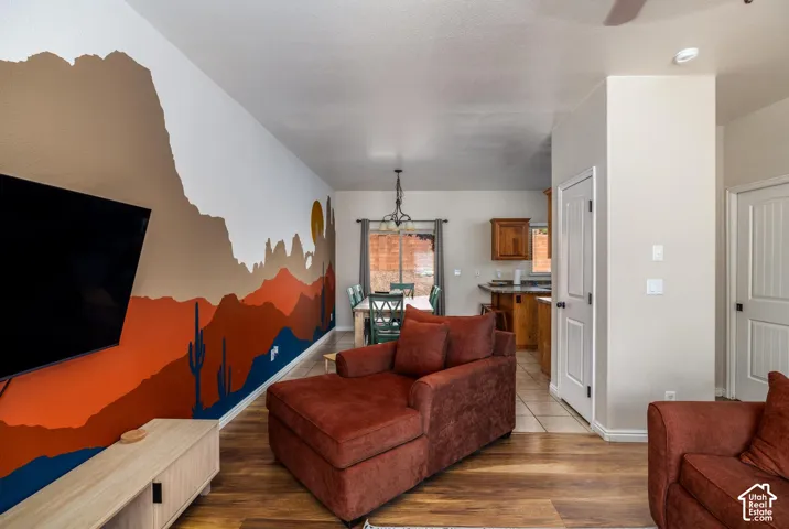 Open-concept living area featuring wood-finish flooring, a decorative wall mural, and recessed lighting