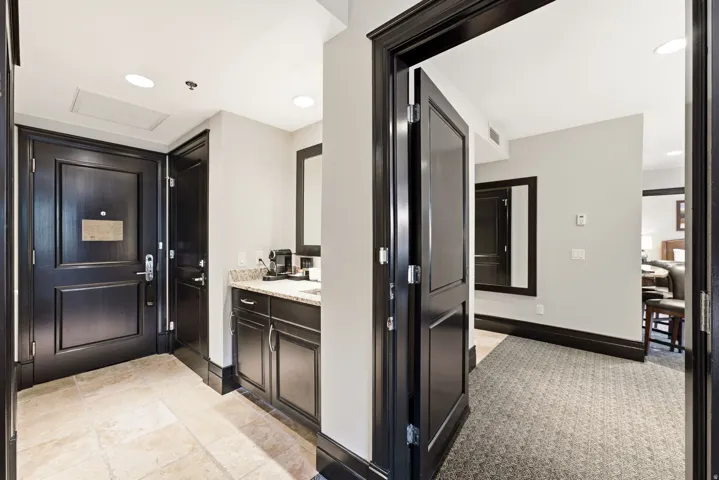 Entry foyer featuring dark wood trim, recessed lighting, and stone tile flooring