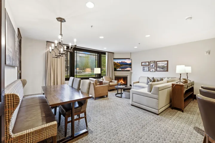 Living area featuring a stone fireplace with a white mantel, recessed lighting, and a window wall