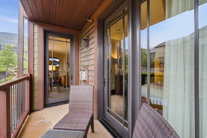 Outdoor balcony featuring an exposed wood ceiling and railing
