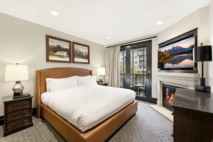 Room featuring a built-in fireplace with a stone mantel, a private balcony with double doors, and recessed lighting