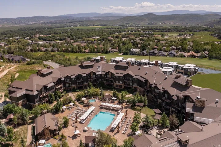 Expansive multi-story building featuring a central courtyard with a large outdoor pool, multiple hot tubs, and lounge areas