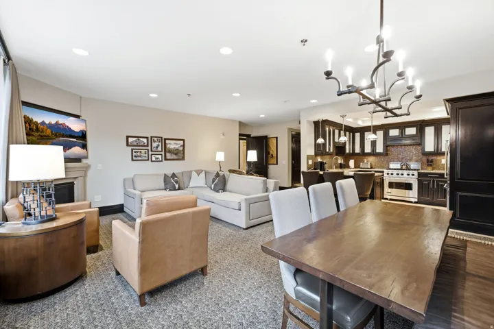 Open-concept living area featuring a fireplace with stone surround, recessed lighting, and wood-finish flooring in the dining area