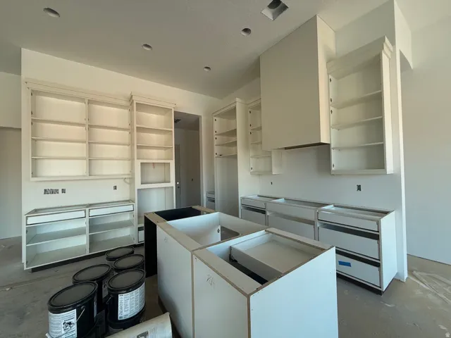 White cabinetry, recessed lighting, and a kitchen island