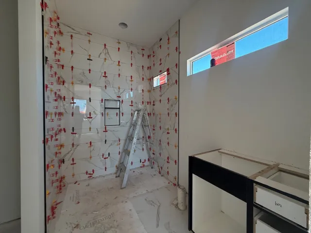 Shower enclosure with large format wall tiles and an integrated shower niche