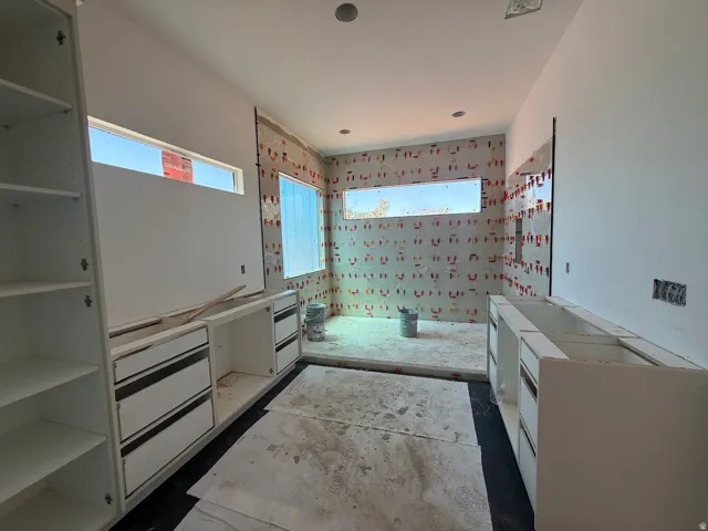 Built-in cabinetry with open shelving, recessed lighting, and strip windows providing natural light