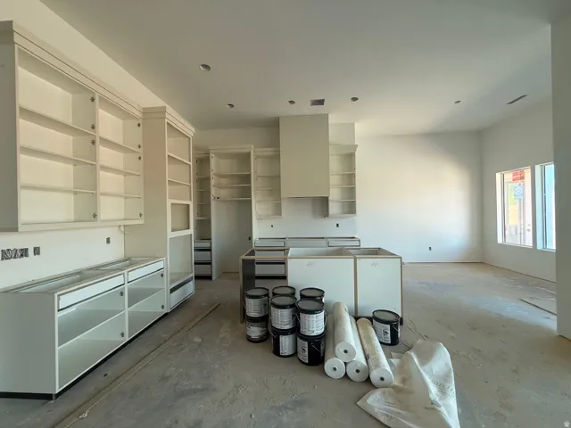 Open-concept kitchen with white cabinetry and an integrated range hood