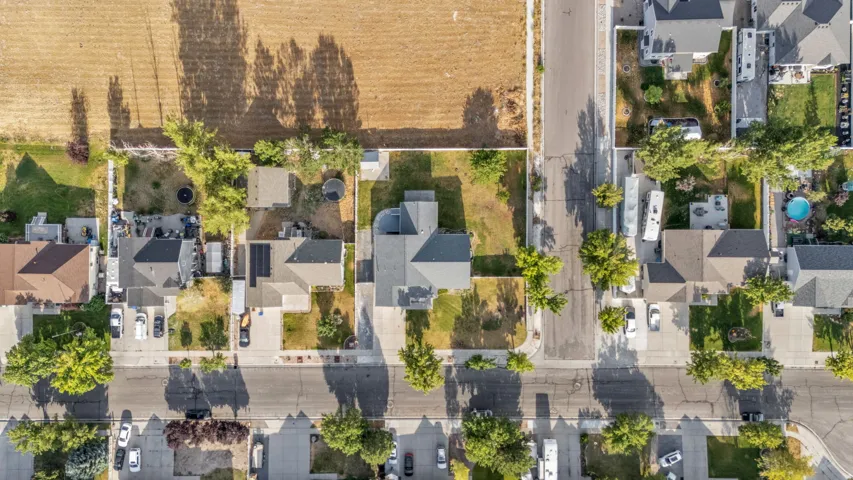 Aerial perspective showcasing a residential street with single-family homes and mature trees