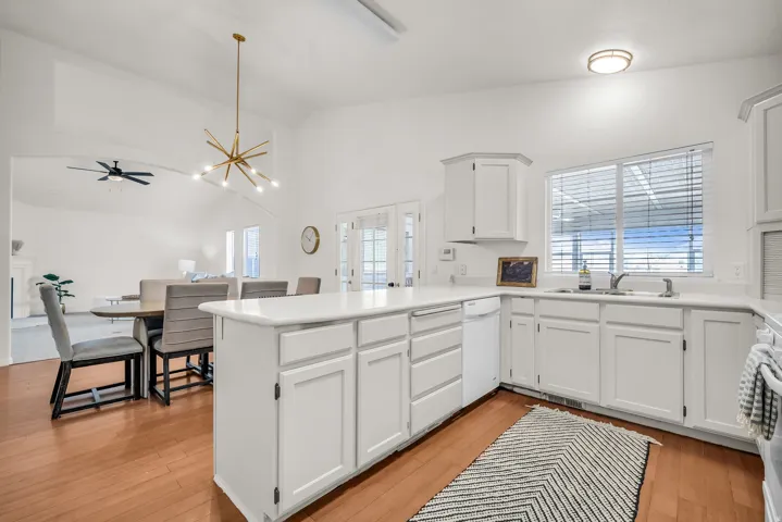 Kitchen featuring a white island, white cabinetry, and light-tone countertops