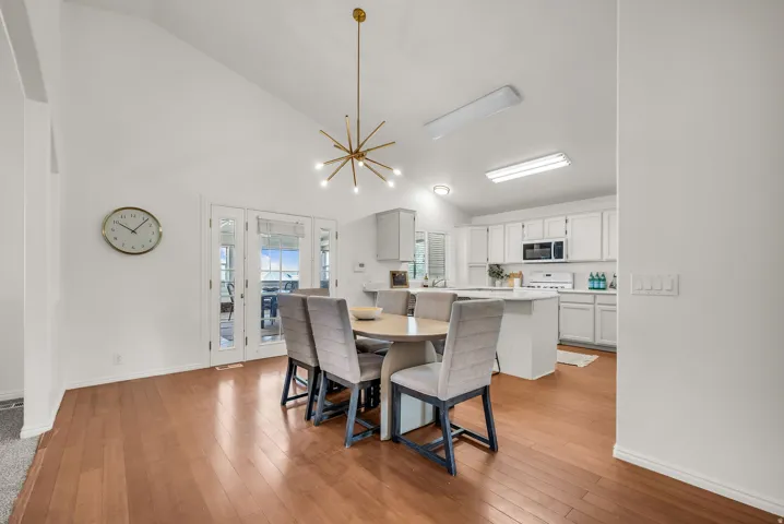 Vaulted ceiling dining area with wood-finish flooring