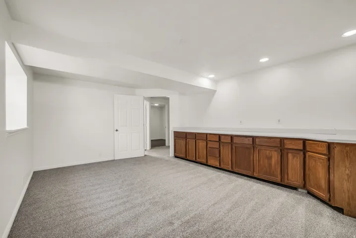 Spacious room featuring extensive built-in cabinetry with wood-finish doors and a light-toned countertop