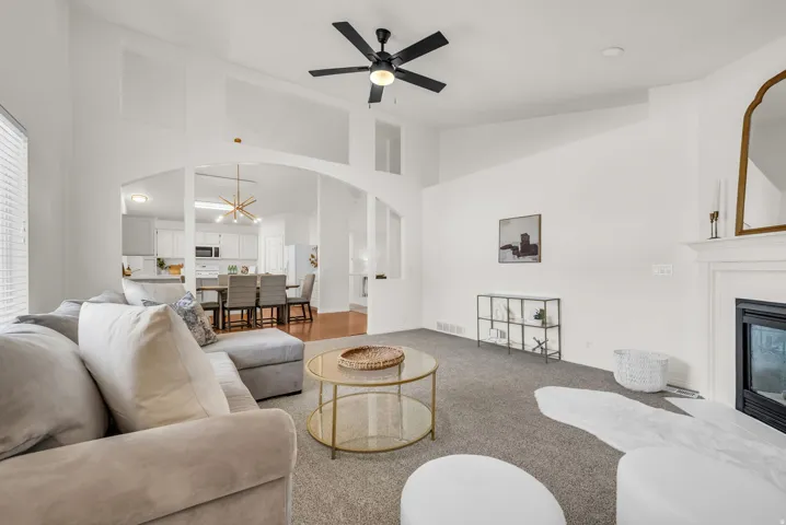 Open-concept living space featuring vaulted ceilings and a black ceiling fan