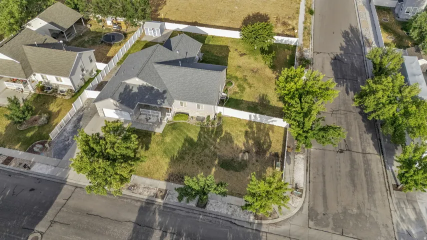 Corner lot residence featuring a two-car garage, front porch, and mature trees