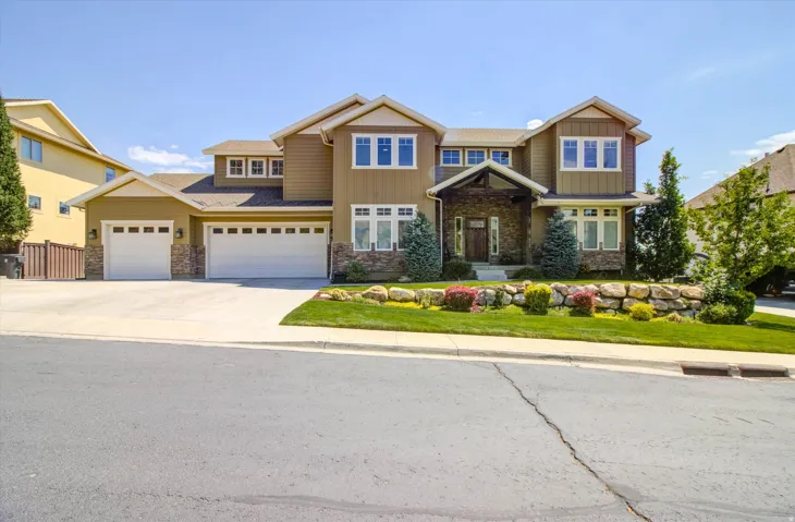 Multi-level exterior featuring earth-toned siding and stone accents