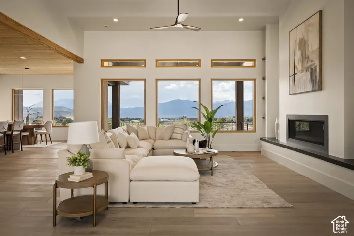 Spacious living area featuring high ceilings, wood-finish flooring, and a contemporary fireplace with a dark stone hearth