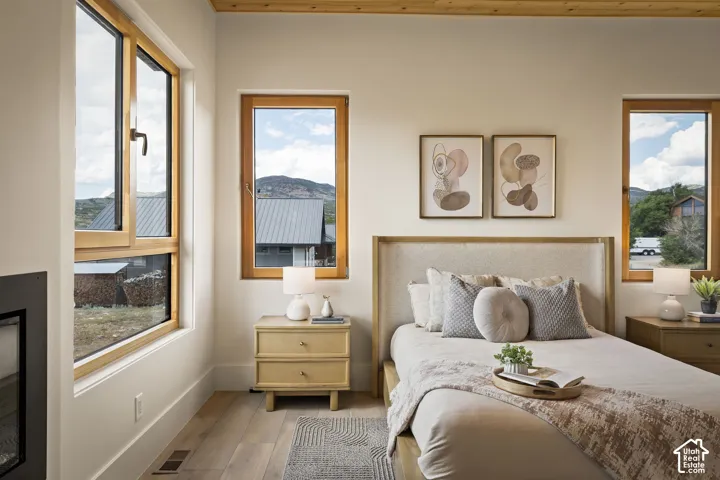 Bright interior featuring light wood-finish flooring and multiple windows with natural wood frames