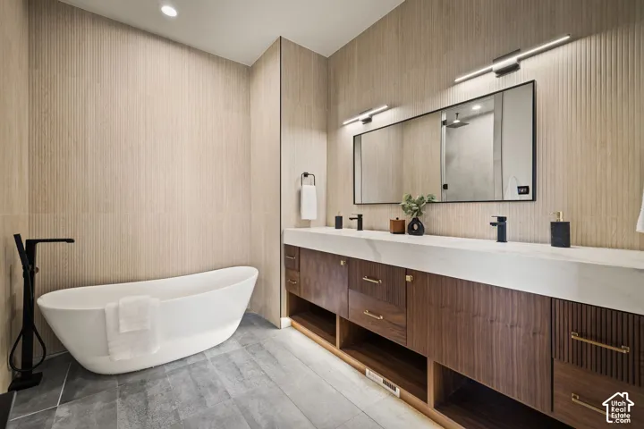 Freestanding soaking tub with floor-mounted matte black faucet