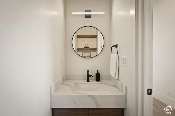 Bathroom vanity featuring a rectangular integrated sink, patterned countertop, and wood-finish cabinetry