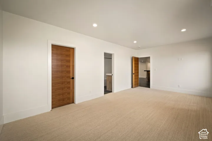 Spacious room with plush carpet flooring and recessed lighting
