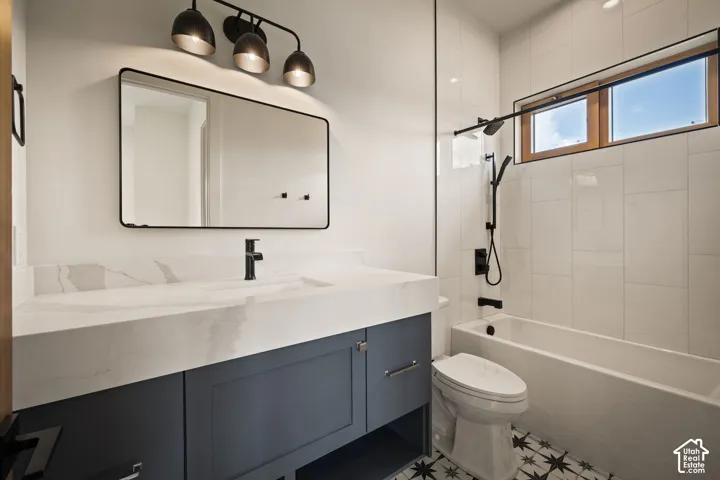 Modern bathroom featuring a dark blue vanity with a white solid-surface countertop and integrated sink
