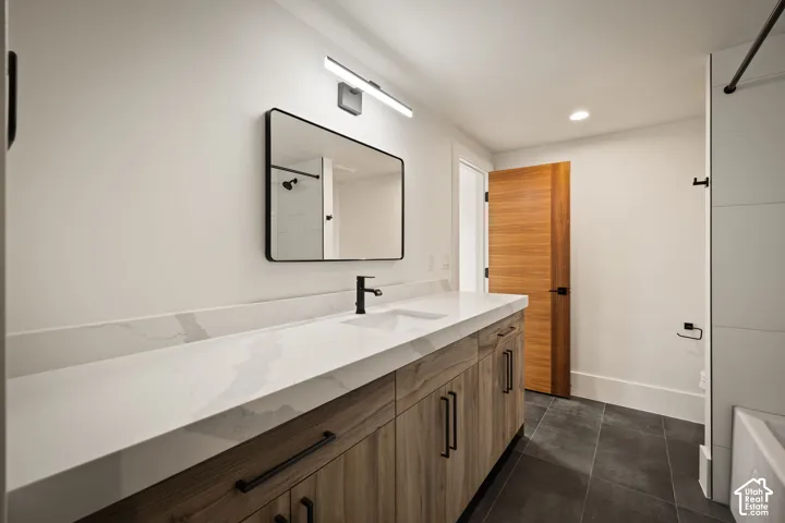 Contemporary bathroom featuring a wood-finish vanity with ample storage, a white countertop with integrated sink, and matte black fixtures