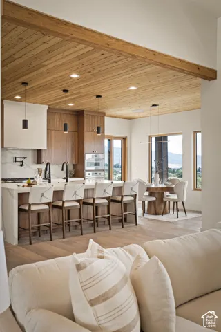 Kitchen featuring a wood-planked ceiling with exposed beam, recessed lighting, and a kitchen island with seating