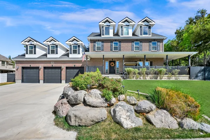 Brick exterior with white dormer windows and black shutters