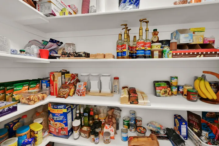 Built-in " Hidden" pantry storage featuring multiple levels of shelving