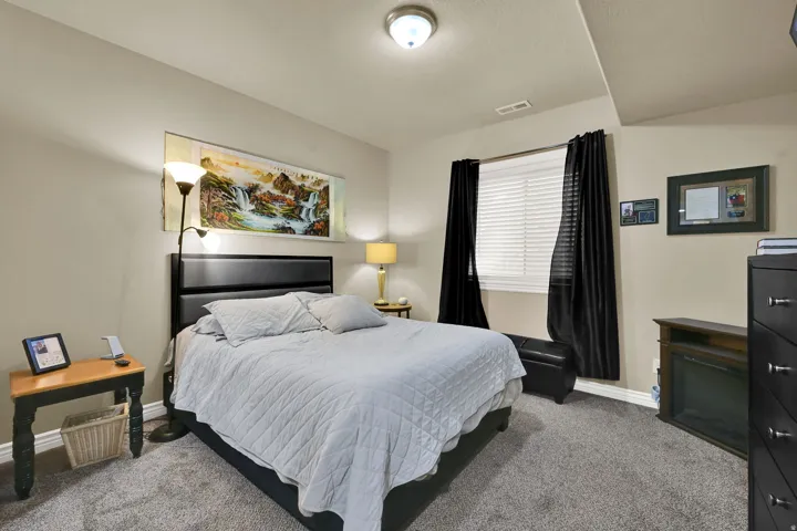 Carpeted room featuring a window with horizontal blinds and dark drapery, a ceiling-mounted light fixture, and a built-in electric fireplace