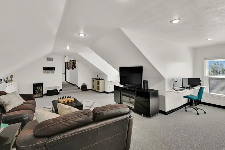 Carpeted bonus room with sloped ceilings and recessed lighting