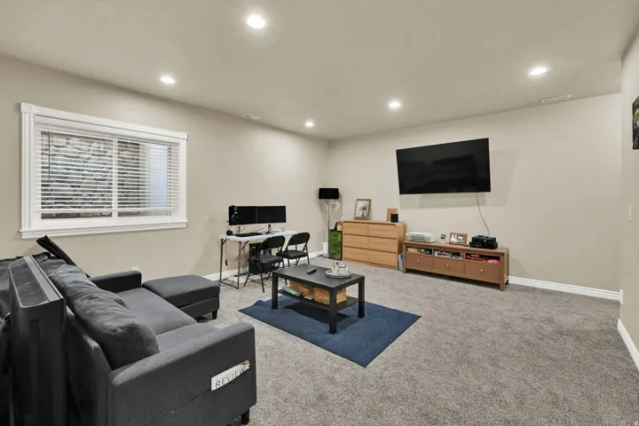 Spacious room featuring neutral paint, recessed lighting, white trim, and a window with horizontal blinds