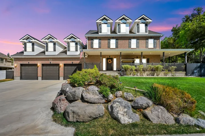 Brick exterior with dormer windows and a covered front porch