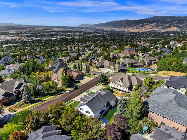 Expansive residential area with a diverse collection of homes, mature trees, and mountainous backdrops