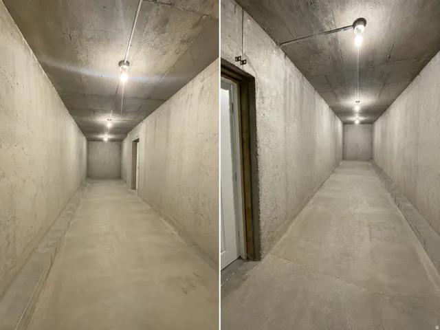 Concrete hallway featuring exposed conduit lighting and a solid core door frame