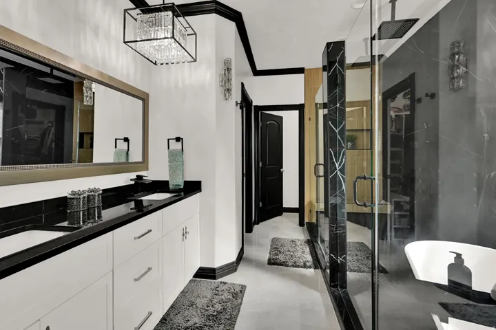 Dual vanity featuring white cabinetry and black countertops