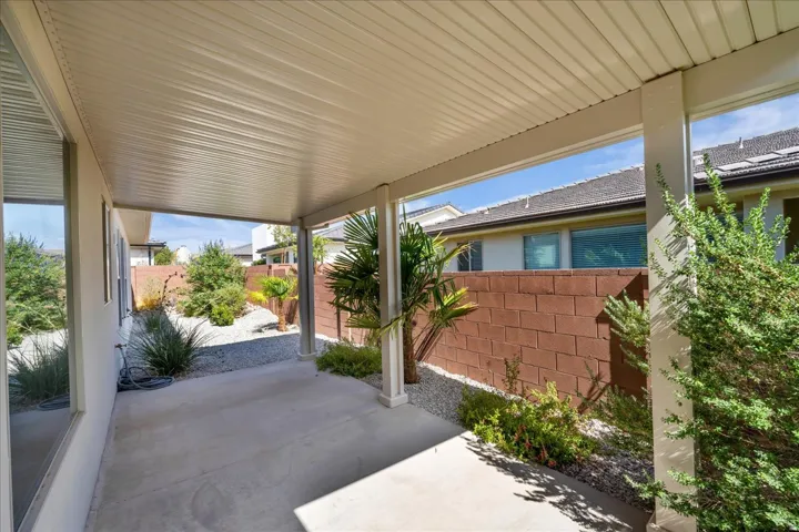 Covered patio featuring a concrete slab and white support columns