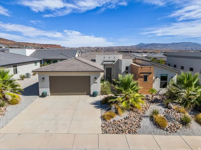 Contemporary stucco exterior featuring a tiled roof and integrated garage
