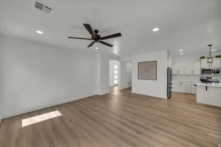 Open-concept living area featuring wood-finish flooring, recessed lighting, and a contemporary ceiling fan