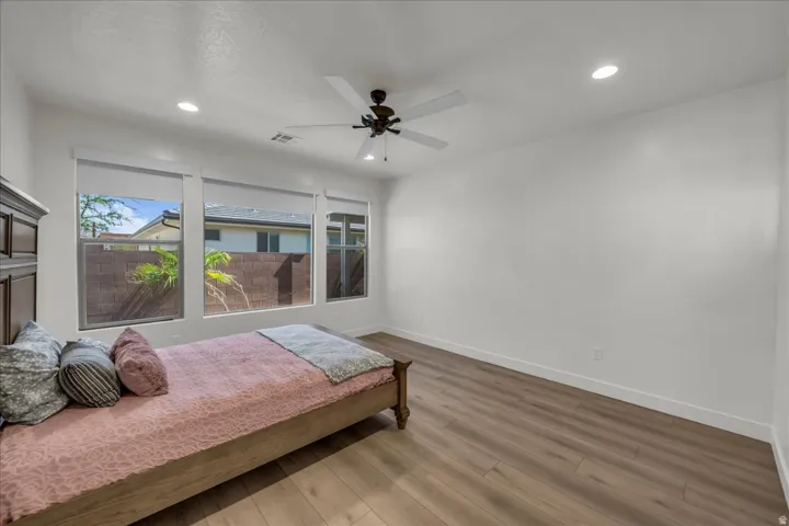 Room with wood-finish flooring, white walls, and recessed lighting