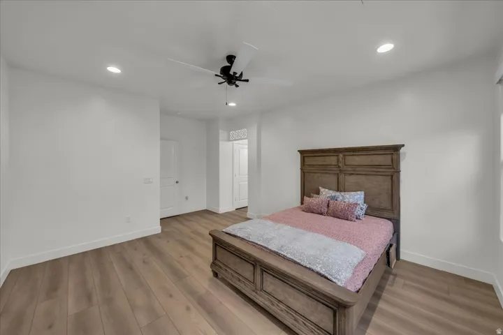 Spacious room featuring wood-finish flooring, white walls, and recessed lighting