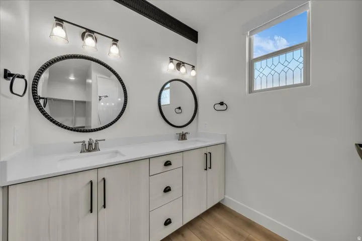 Dual vanity with light wood-finish cabinetry and white countertops