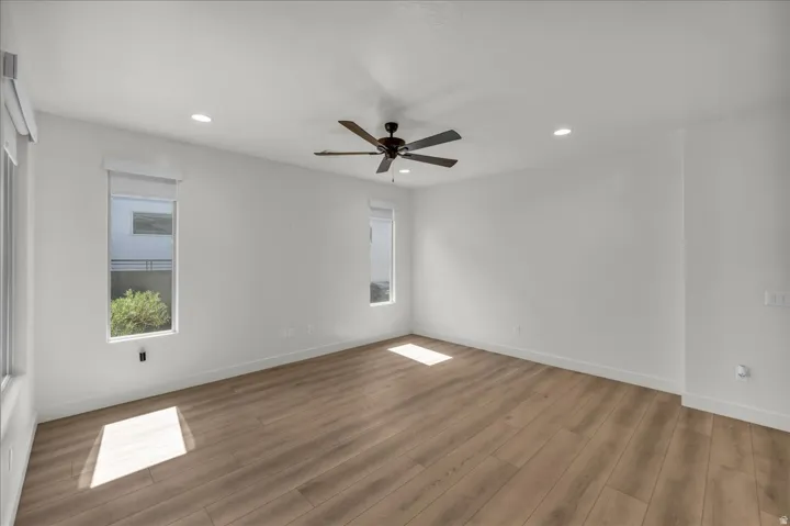 Spacious interior with wood-finish flooring, recessed lighting, and a ceiling fan