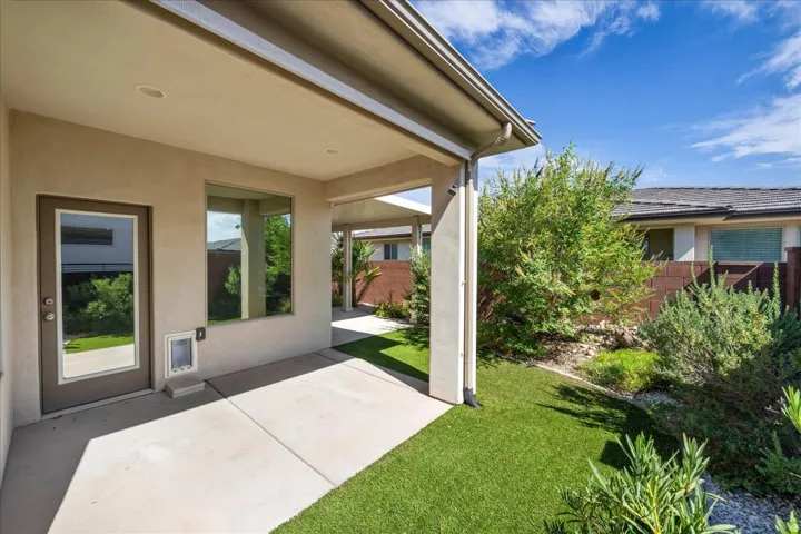 Covered patio with recessed lighting, stucco exterior, and a glass-paneled door