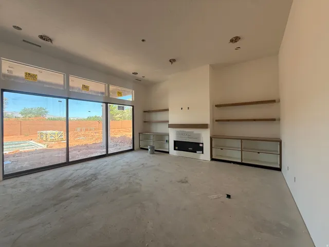 Expansive sliding glass doors, built-in shelving, integrated electric fireplace, and a large window wall