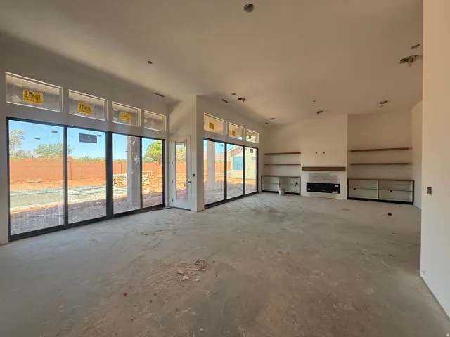 Spacious open-concept living area flooded with natural light through multiple glass sliding doors and transom windows