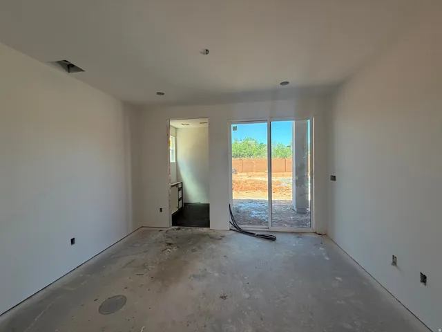 White walls with a sliding glass door providing access to the exterior