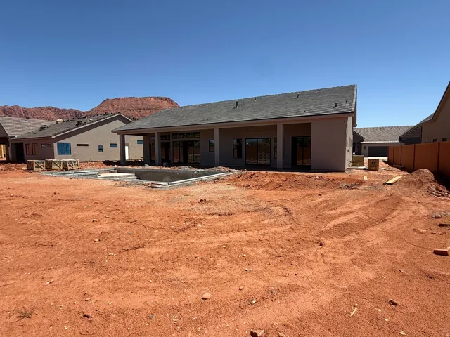 New construction home featuring a modern single-story design with a pitched roof, wide covered front porches, and multi-panel glass doors