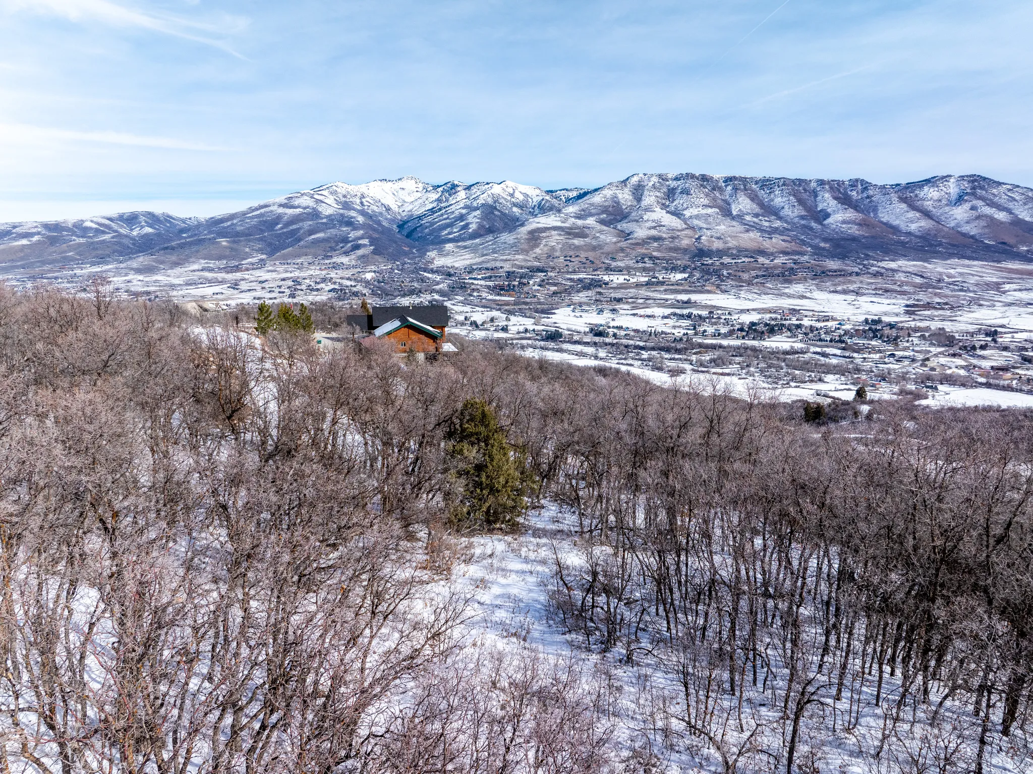 Expansive mountain scenery framing a distinct brown-sided residence with a dark roof